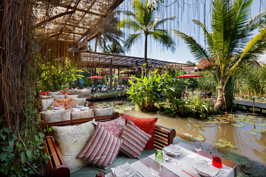 Manda de Laos pond-side lounge seating and dining tables